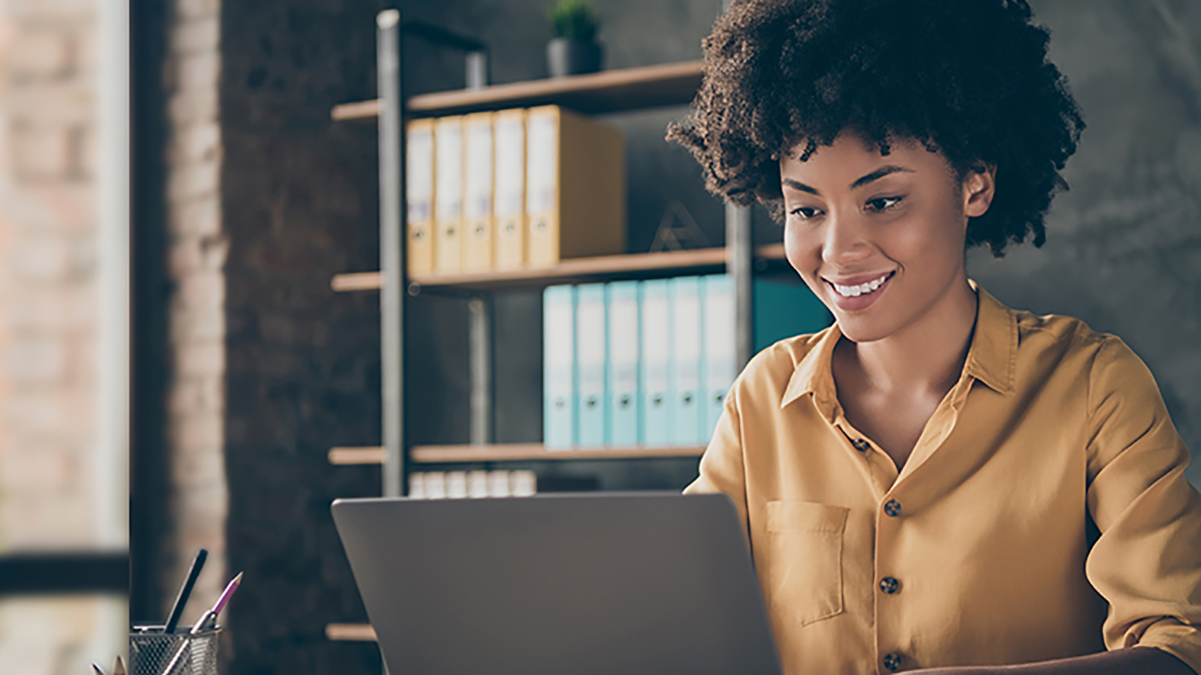 Woman smiling while working on a laptop