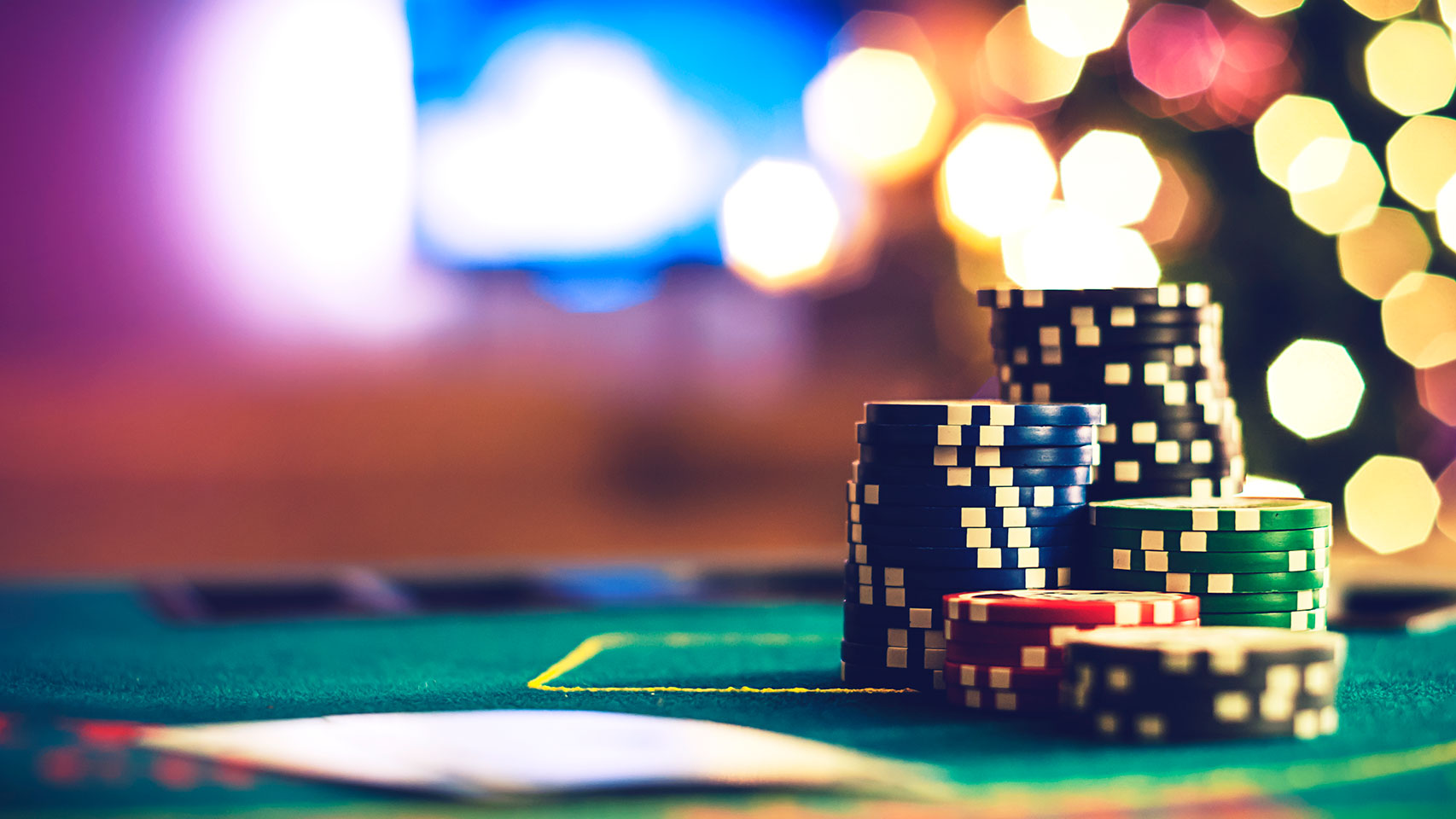 Closeup view of poker chips and cards sitting on green felt