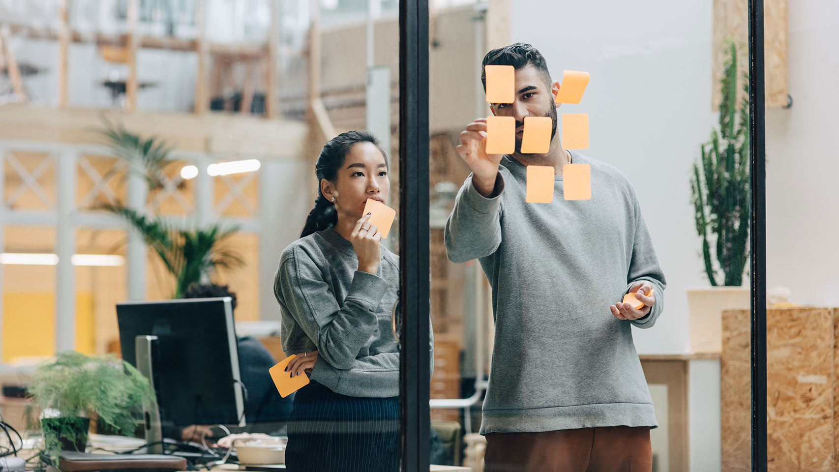 Two colleagues working on project in a conference room planning with post-it notes