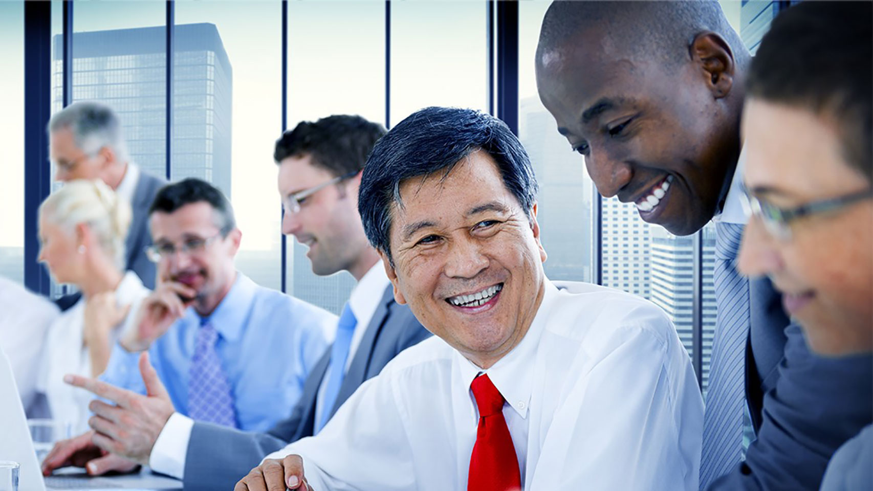 Businessman smiling at a peer in a group setting