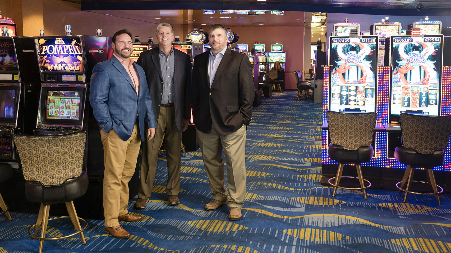 Men in suits standing in a casino, posing for the camera