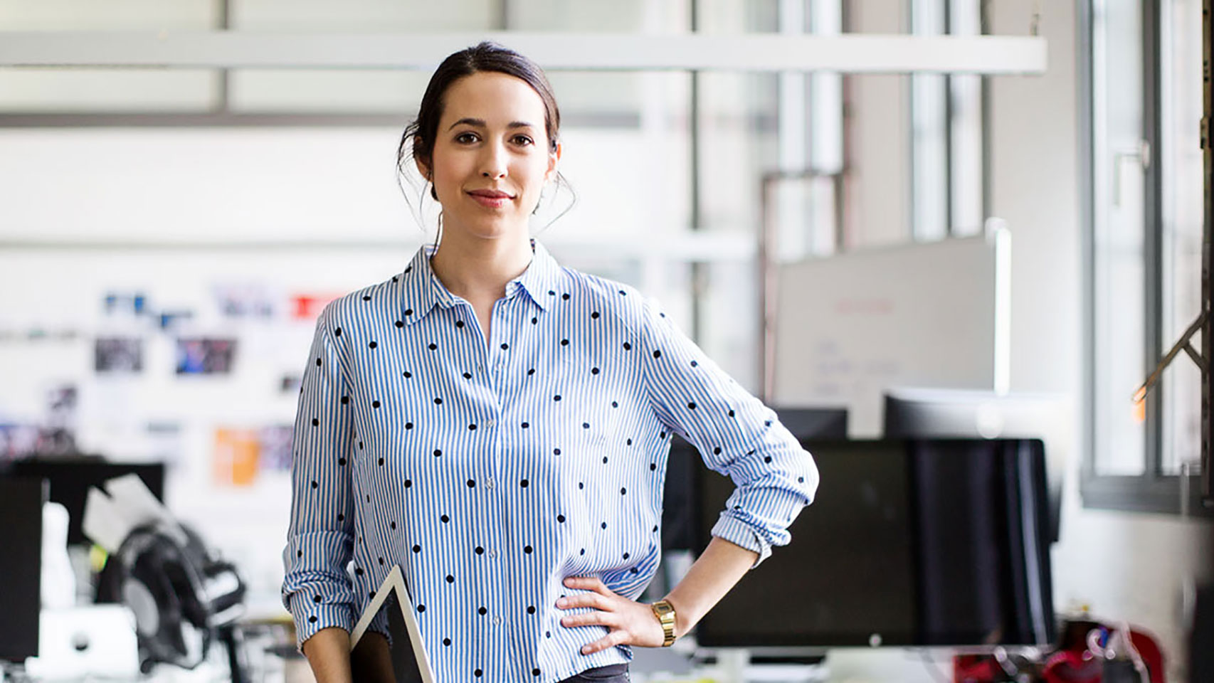 Young businesswoman with her hand on her hip smiling at the camera