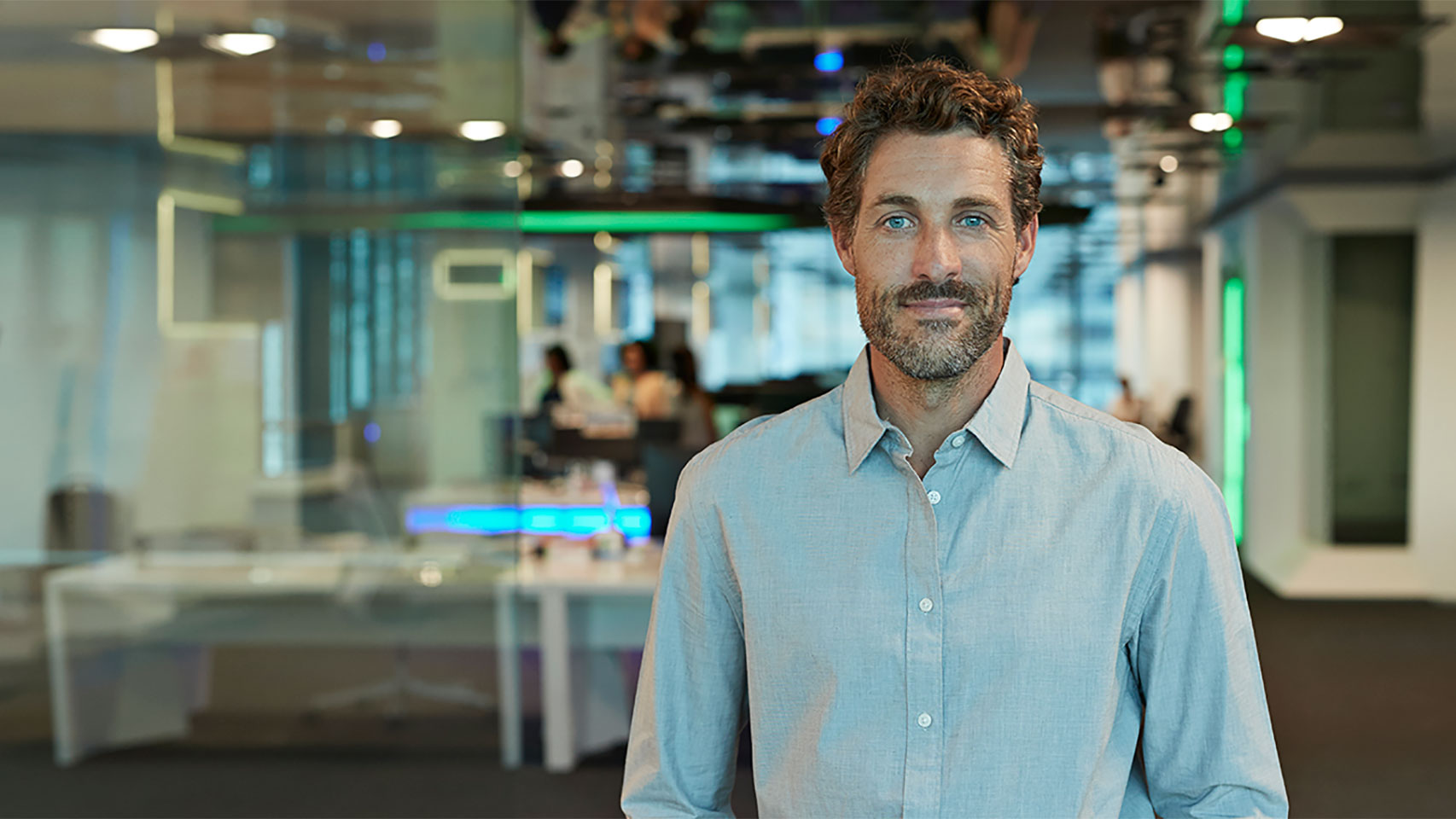 Businessman standing in a office space looking at the camera