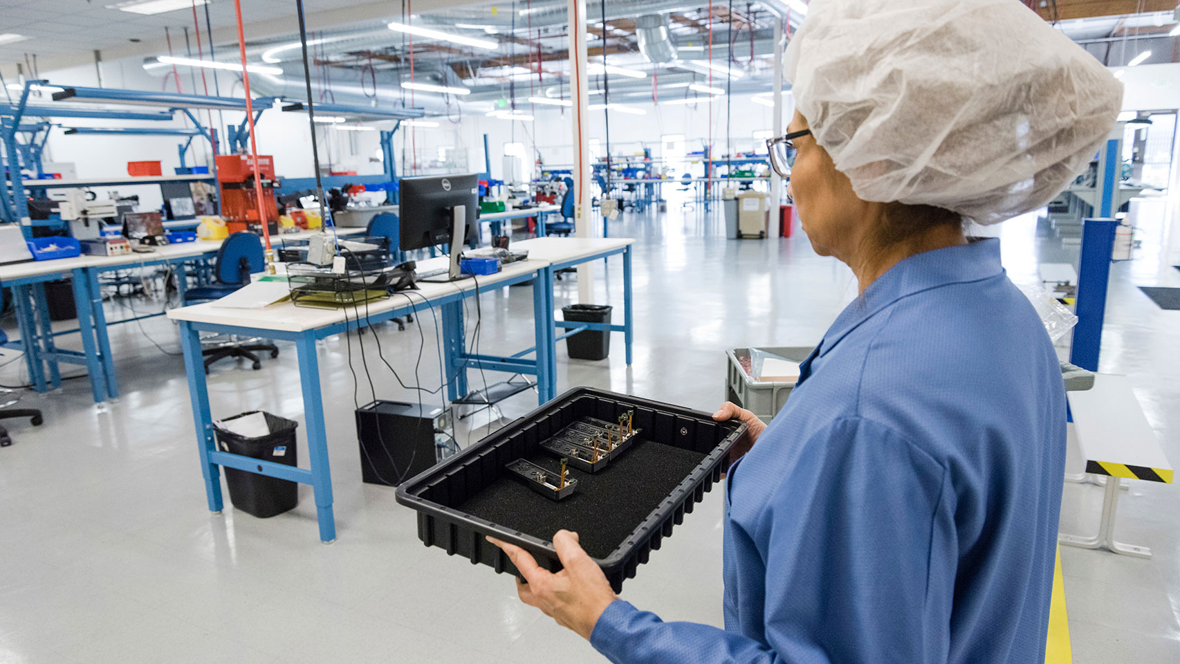Woman carrying a tray in a lab