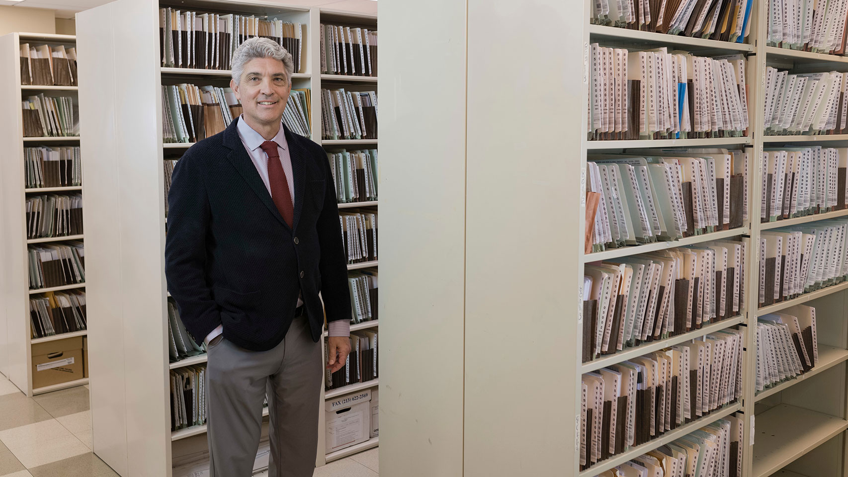 Man posing in a legal document file room