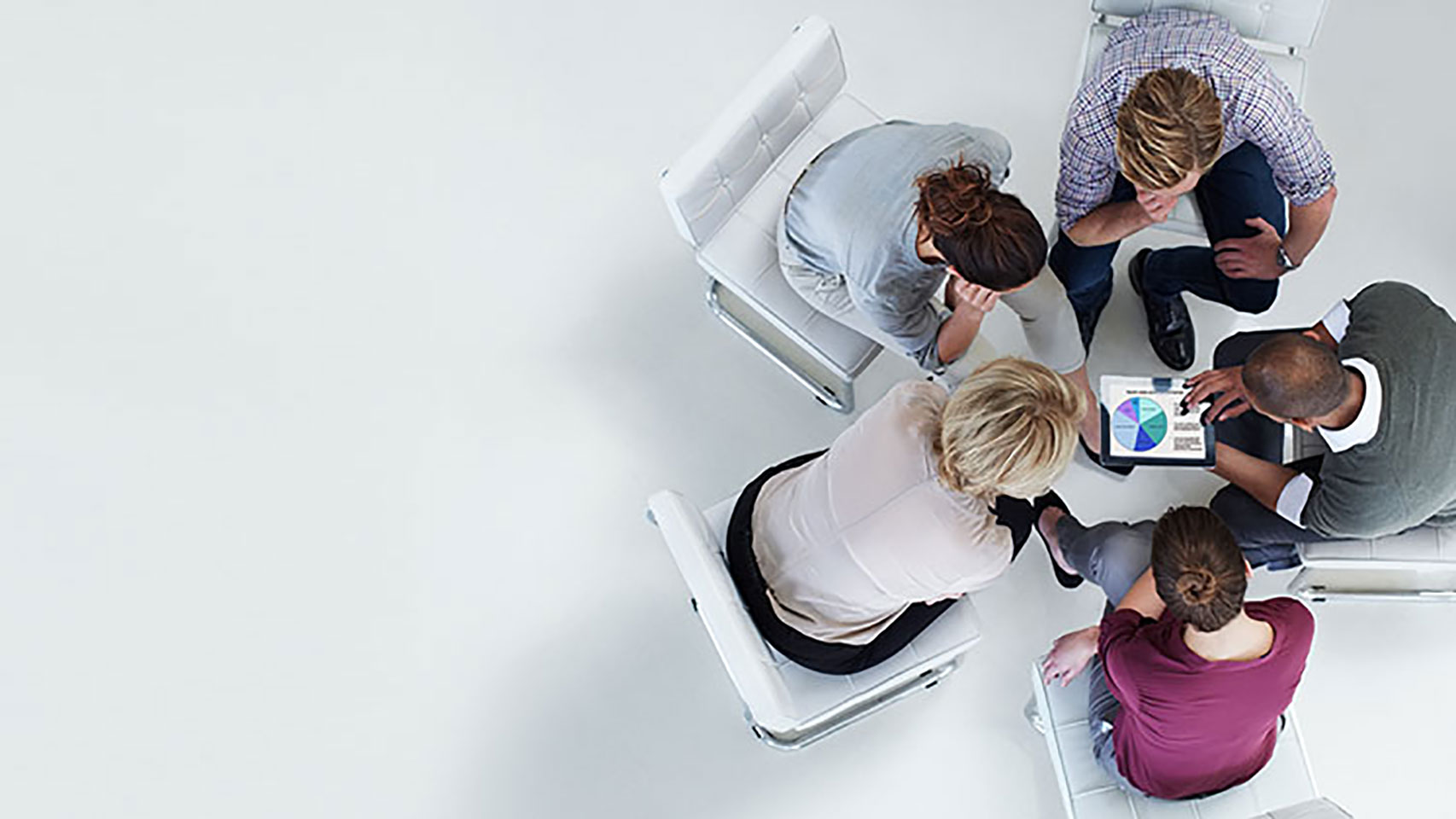 A small group of people looking at a shared tablet