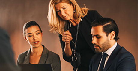 Woman standing up and talking to a business man and woman