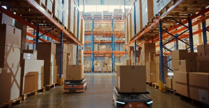 Photo of a wharehouse with boxes stacked high on shelves.