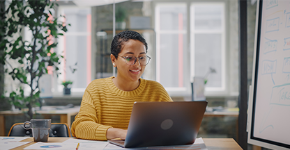 Young woman sitting at a desk on a laptop computer.