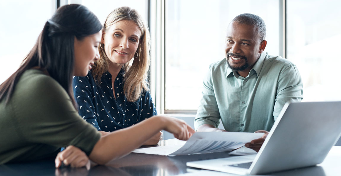 Two small business owners sitting at a table with a banker