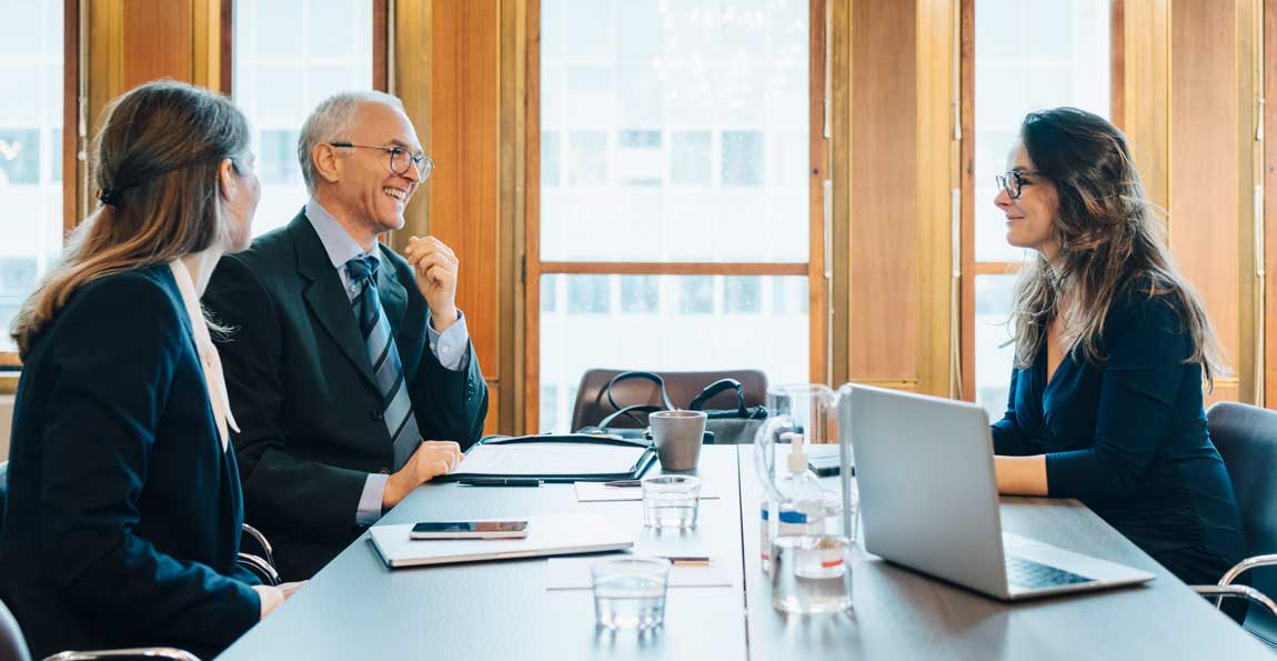 Two business owners discussing succession planning with a corporate lawyer