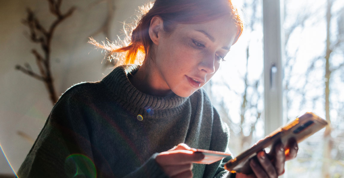 A young woman checking her credit card statement on her mobile phone