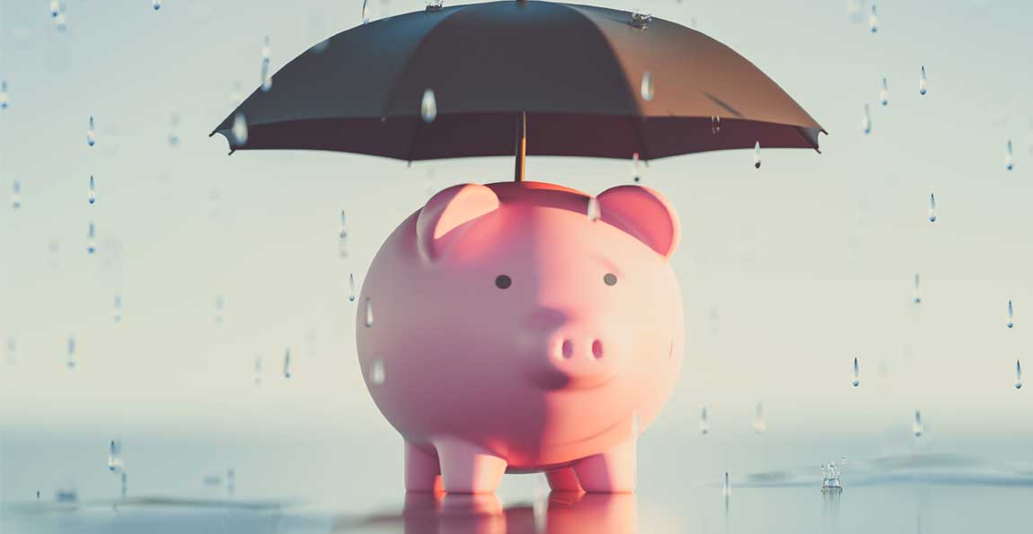 A piggybank with an umbrella staying dry in the rain