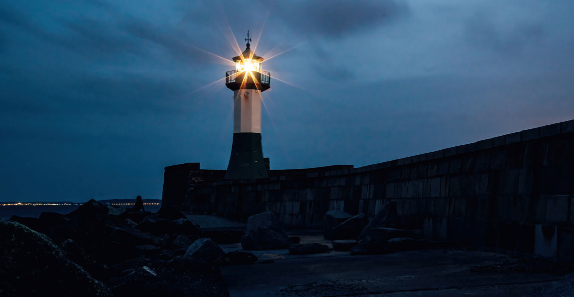 A bright lighthouse in a darkening storm