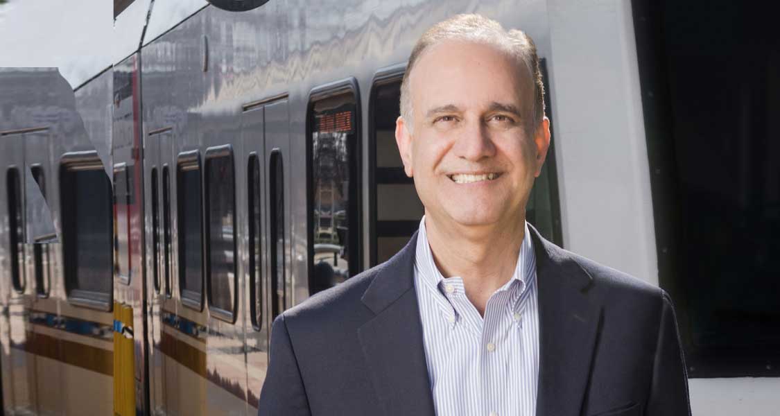 Businessman standing in front of a public transit train