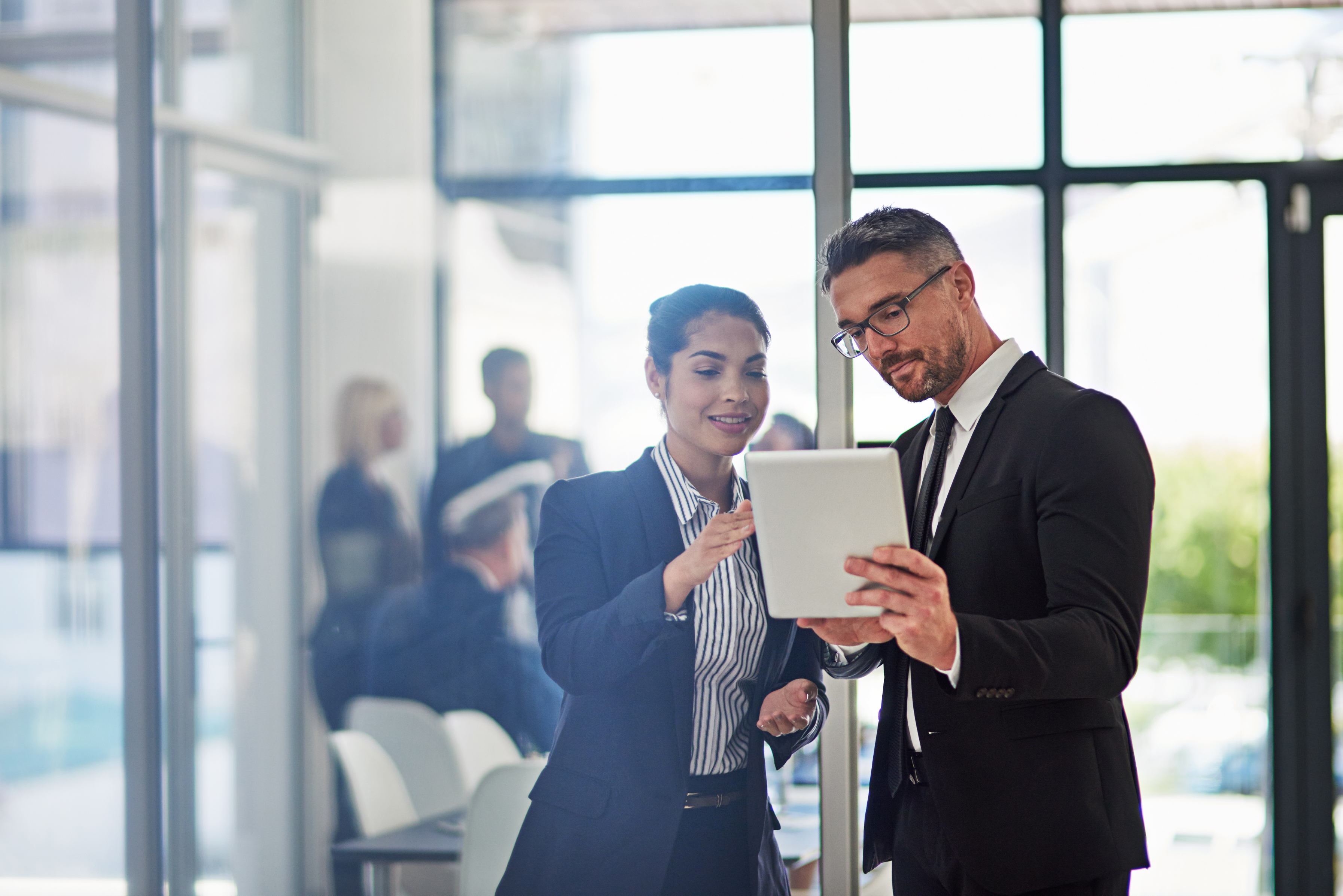 Bankers discussing information on a tablet