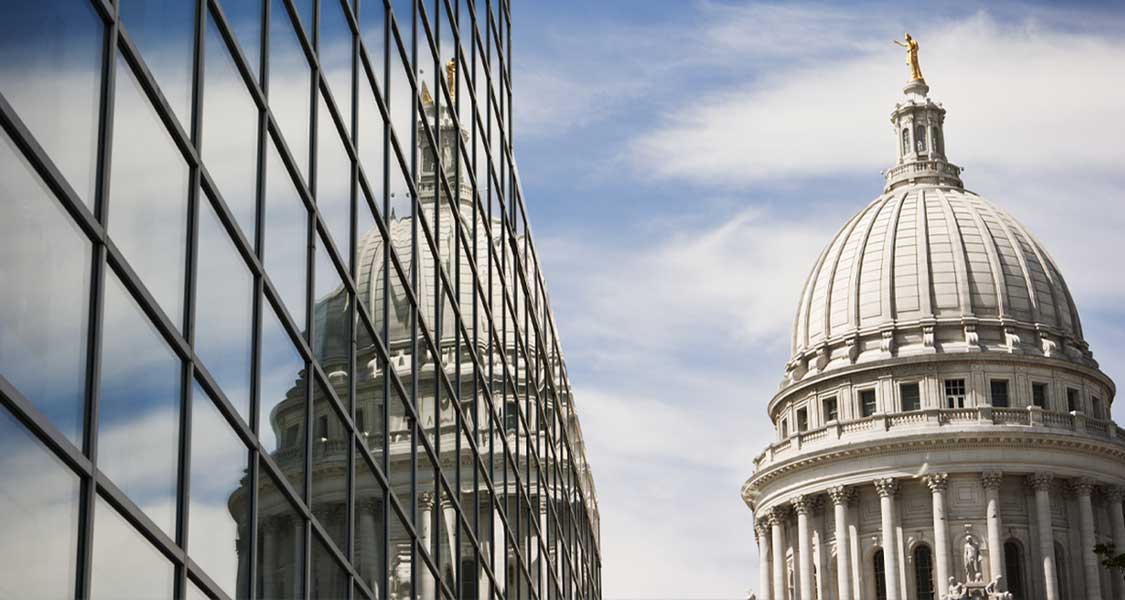 A domed government building and a cloudy, blue sky