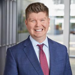 A man in a suit smiling for a photo