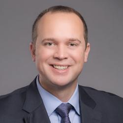 A man in a suit smiling for a photo