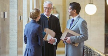 standing judge and two lawyers in a courthouse