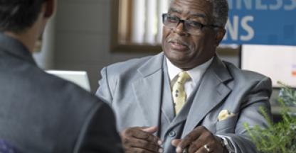 Businessman sitting at a desk across from a customer