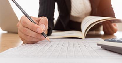 Women filling out general ledger for payroll