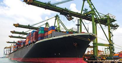 Large cargo ship being loaded in the water