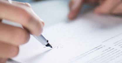 closeup of someone signing a document