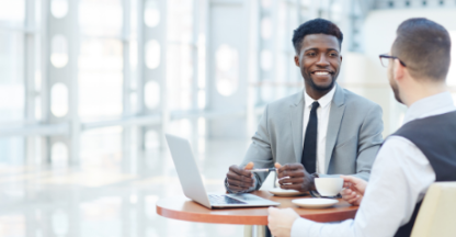 business men enjoying coffee and smiling during meeting
