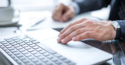 Closeup view of a person's hands on a laptop keyboard