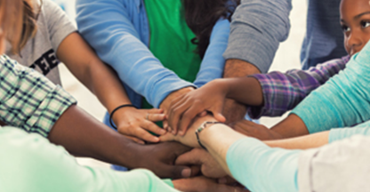 diverse group of people coming together in a team huddle