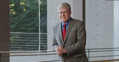 Man leaning against a wire railing