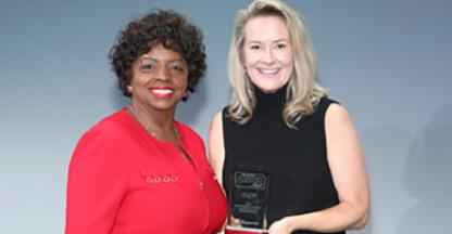 Two business woman showing an award to the camera