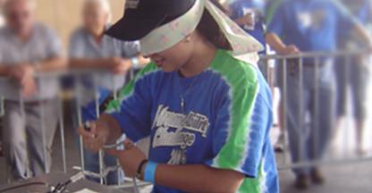 Person with a blindfold on attempting to assemble a project