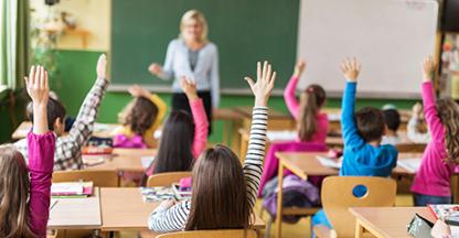 Students raising their hands in the classroom