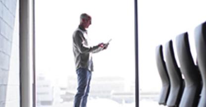 Man standing in a conference room looking at his cell phone