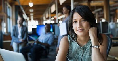 Businesswoman looking into the camera in an open office setting