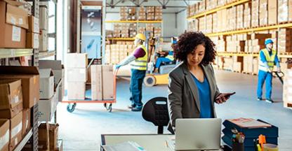 Businesswoman working on a computer in a warehouse