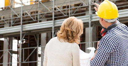 Two people reviewing plans on a construction site