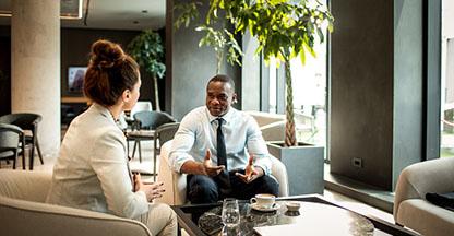 Woman and man sitting down and having a meeting.