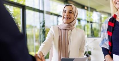 Woman shaking hand of person in a bank