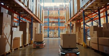 Photo of a wharehouse with boxes stacked high on shelves.