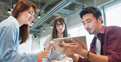 Group of young business people looking at a tablet computer.