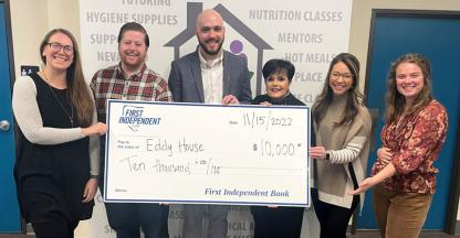 A group of nonprofit employees holding a large donation check