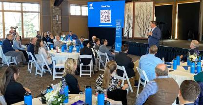 A man speaking to a room full of convention attendees