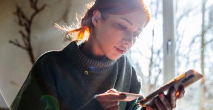 A young woman checking her credit card statement on her mobile phone