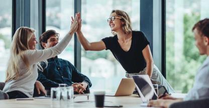 Two female business professionals giving each other a high five