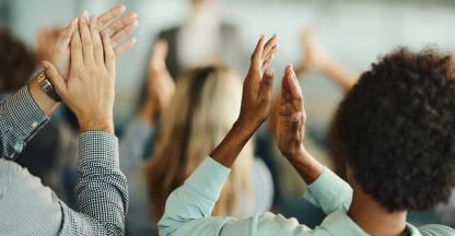 Colleagues applauding the promotion of their coworkers