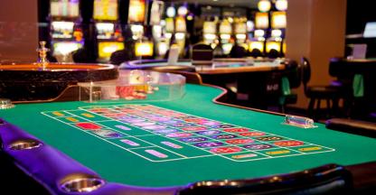 A roulette table and slot machines on a casino floor