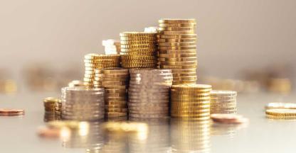 Stacks of gold coins representing saving money for nonprofit organizations